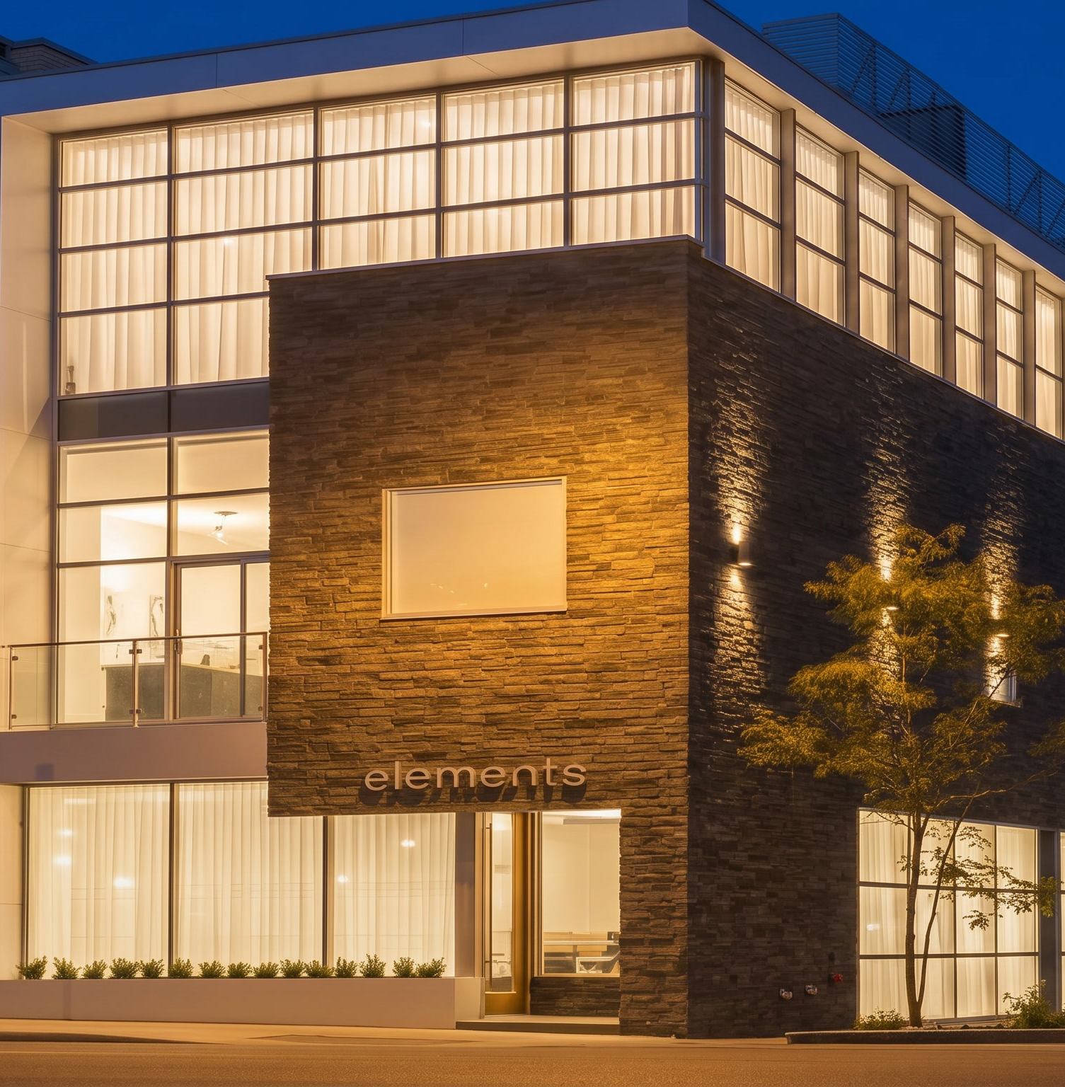 Modern office building entrance with “elements” sign, glass windows, and evening exterior lighting