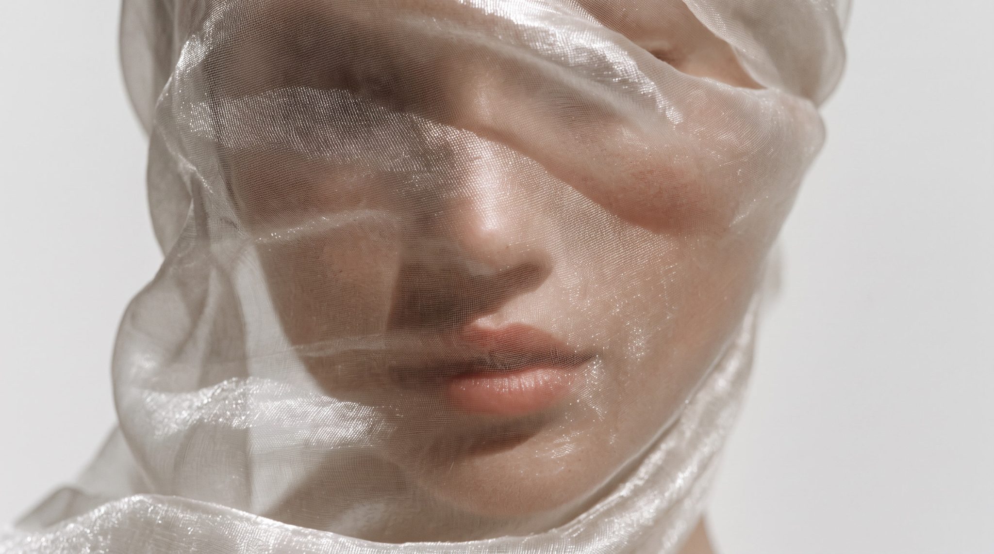 Softly veiled face with delicate features.